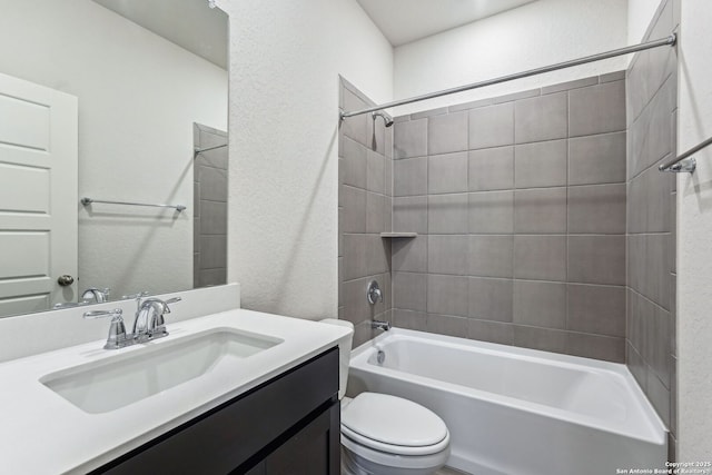 full bathroom featuring vanity, tiled shower / bath combo, and toilet