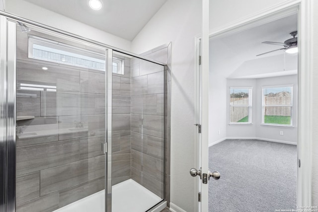 bathroom with a shower with door, vaulted ceiling, and ceiling fan