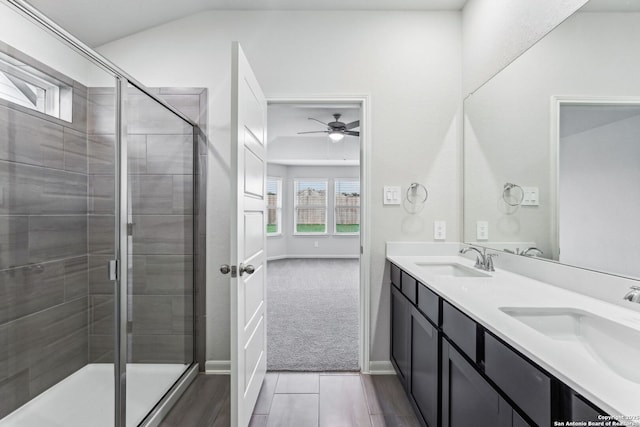 bathroom with vanity, vaulted ceiling, ceiling fan, and walk in shower