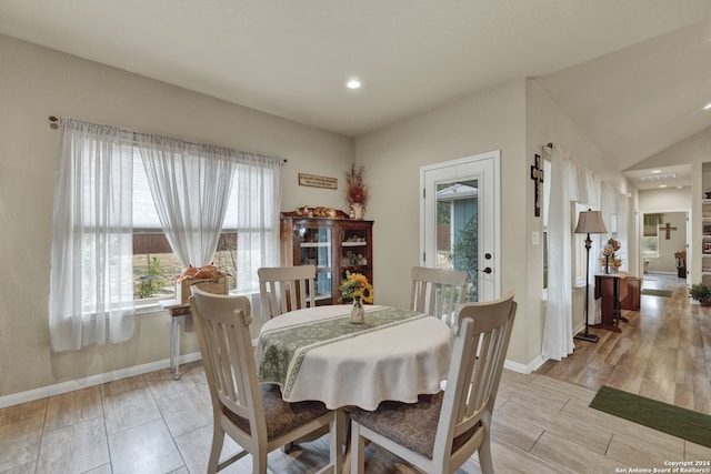 dining space featuring light hardwood / wood-style flooring and vaulted ceiling