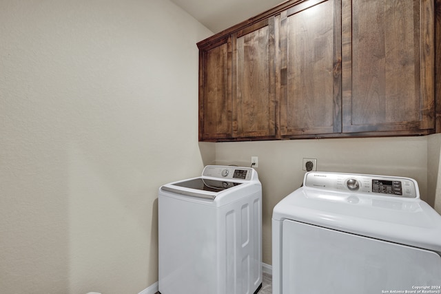 washroom with independent washer and dryer and cabinets