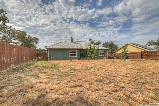 rear view of property with a yard