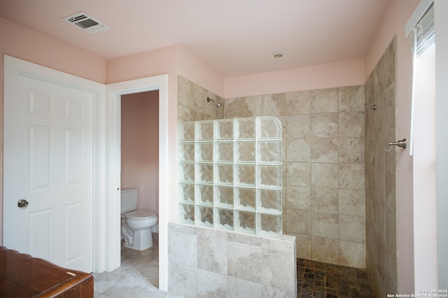 bathroom with toilet and tiled shower