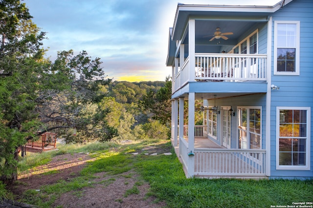 exterior space with ceiling fan and a balcony