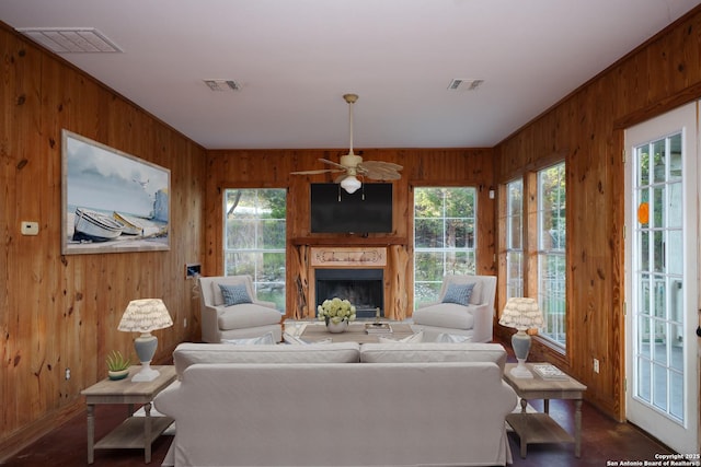 282 Hill Top, Lakehills, TX 78063 - living area featuring wooden walls, healthy amount of natural light, a ceiling fan, a high end fireplace, and baseboards