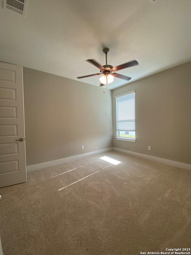 carpeted spare room featuring ceiling fan