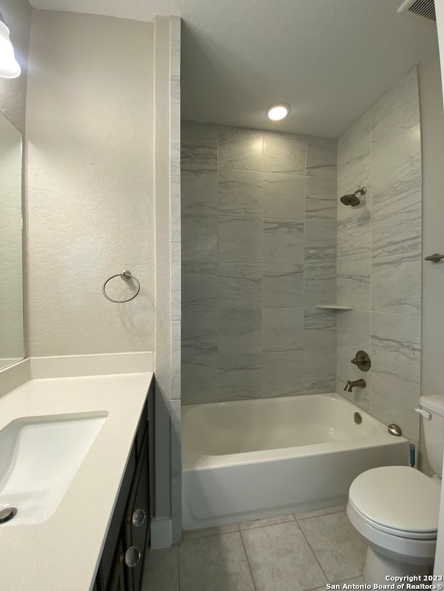 full bathroom featuring tiled shower / bath, vanity, toilet, and tile patterned flooring