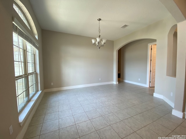 unfurnished room featuring light tile patterned floors and an inviting chandelier