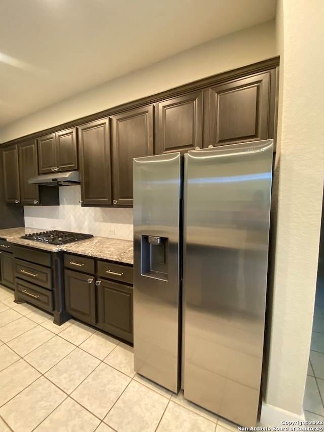 kitchen featuring appliances with stainless steel finishes, dark brown cabinets, and light tile patterned flooring