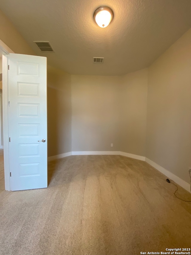 carpeted spare room with a textured ceiling