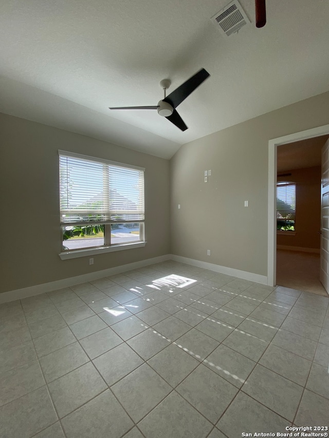 tiled spare room with lofted ceiling and ceiling fan