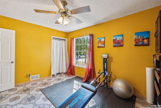 exercise area featuring a textured ceiling and ceiling fan