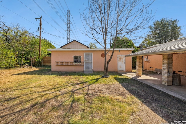 back of property featuring a yard and a patio