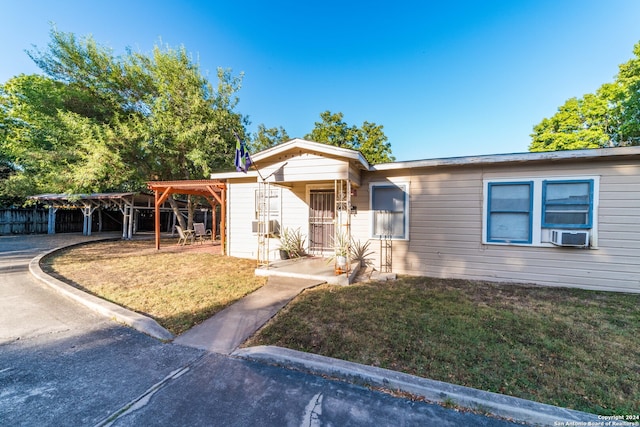 view of front of house with a front yard, cooling unit, and a carport