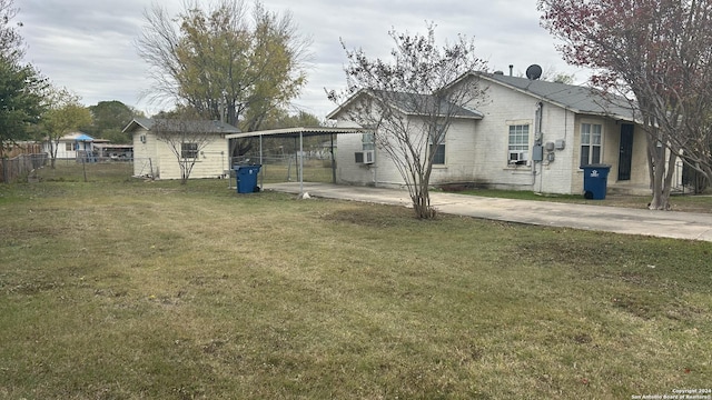 back of property with a carport, a yard, and cooling unit