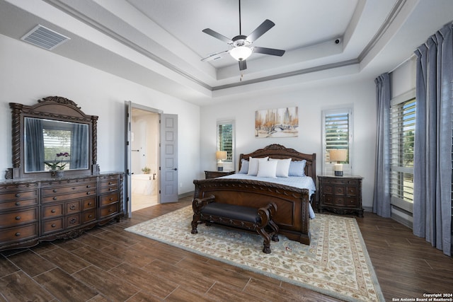 bedroom featuring ensuite bathroom, a raised ceiling, dark hardwood / wood-style floors, and ceiling fan