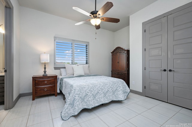 bedroom with a closet, light tile patterned floors, and ceiling fan