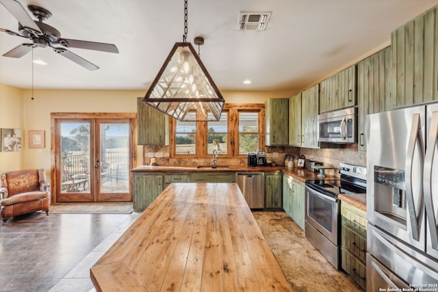 kitchen featuring plenty of natural light, stainless steel appliances, and green cabinetry