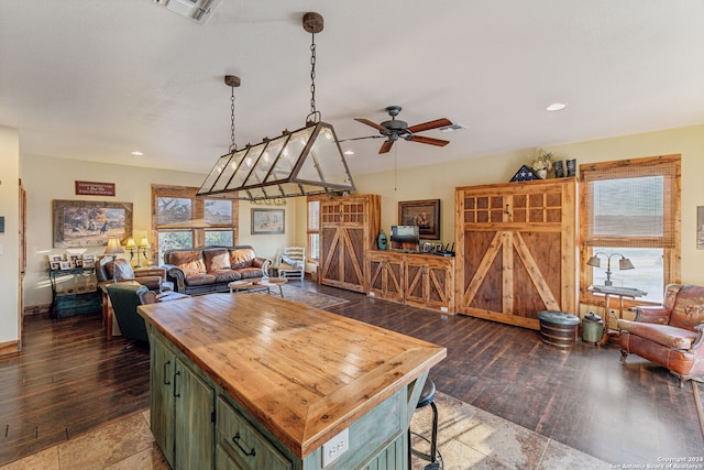 kitchen with dark wood-type flooring, a center island, green cabinets, and ceiling fan