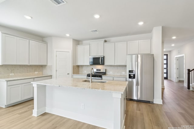 kitchen with appliances with stainless steel finishes, light wood-type flooring, and white cabinetry