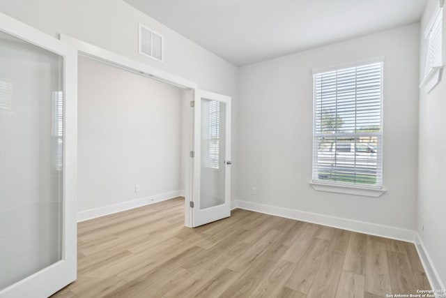 unfurnished bedroom with light hardwood / wood-style flooring and french doors