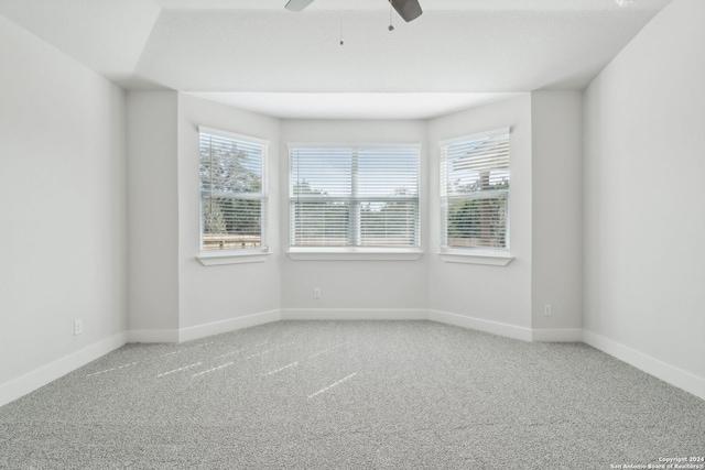 spare room featuring ceiling fan, carpet floors, and a healthy amount of sunlight