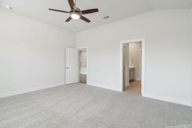 unfurnished bedroom with ceiling fan, light colored carpet, connected bathroom, and vaulted ceiling