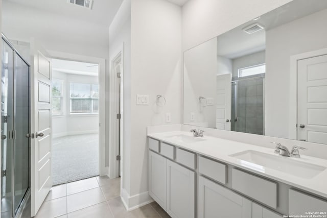 bathroom featuring tile patterned floors, a wealth of natural light, vanity, and an enclosed shower