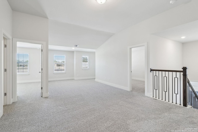 unfurnished room with light carpet and lofted ceiling