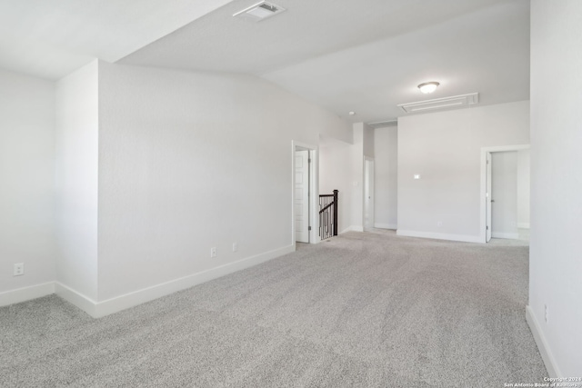 spare room featuring carpet flooring and lofted ceiling