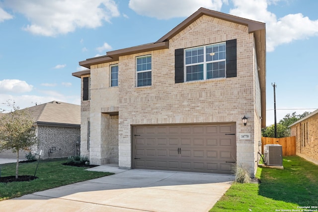 view of front of home with a garage, a front lawn, and central air condition unit