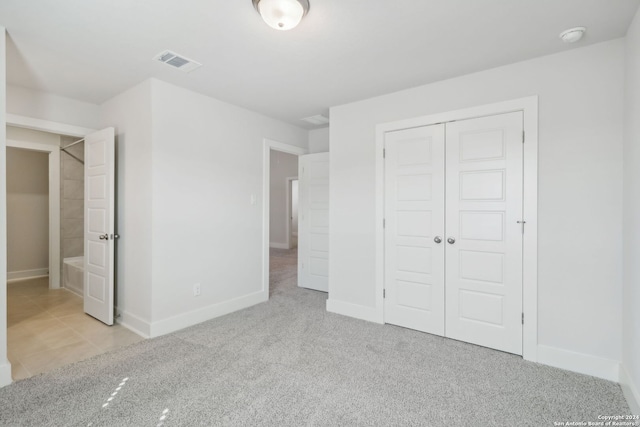 unfurnished bedroom with light carpet and a closet