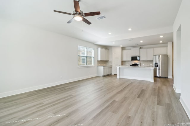 unfurnished living room with ceiling fan and light hardwood / wood-style flooring