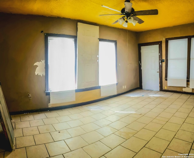 tiled empty room with ceiling fan