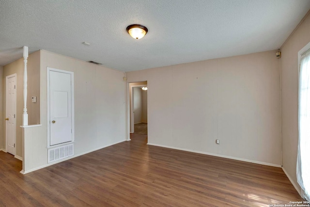 unfurnished room with dark hardwood / wood-style floors and a textured ceiling