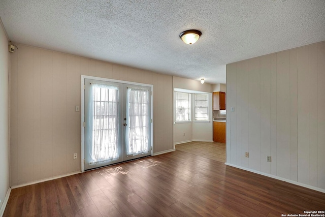 spare room featuring french doors, a textured ceiling, and wood-type flooring