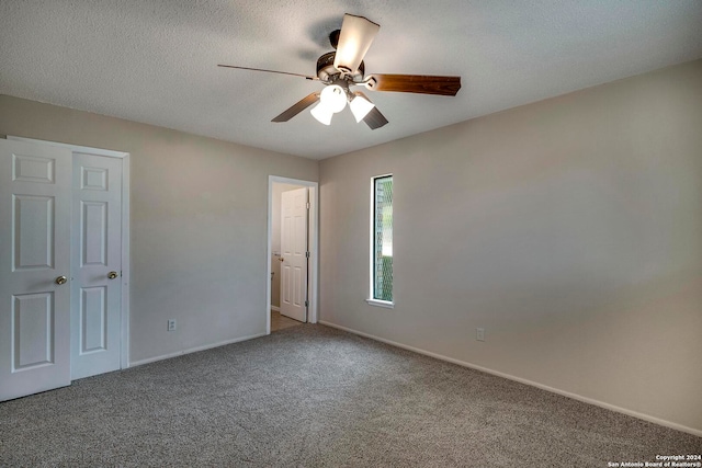 unfurnished bedroom with a textured ceiling, carpet flooring, and ceiling fan