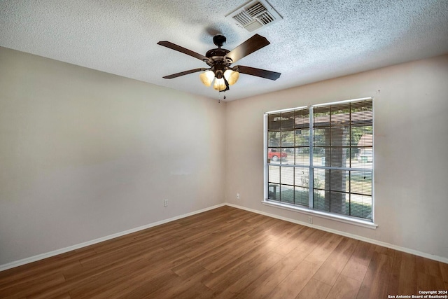 spare room featuring a textured ceiling, wood-type flooring, and ceiling fan