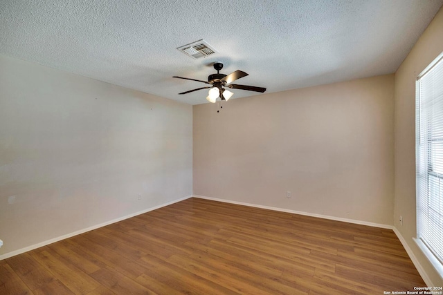 spare room featuring a textured ceiling, wood-type flooring, and ceiling fan