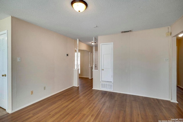 spare room with dark hardwood / wood-style floors and a textured ceiling