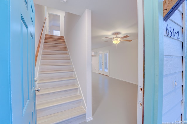 stairway featuring ceiling fan