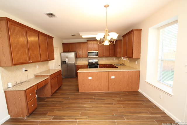 kitchen featuring dark wood-type flooring, stainless steel appliances, sink, and decorative light fixtures