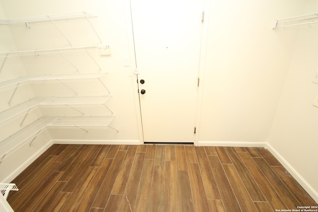 walk in closet with dark hardwood / wood-style floors