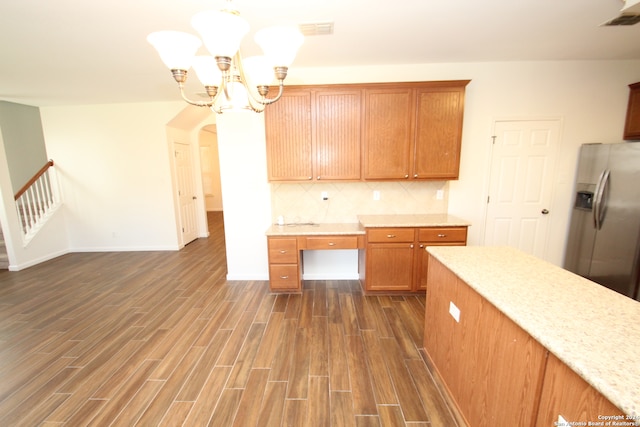 kitchen featuring a notable chandelier, hanging light fixtures, dark hardwood / wood-style floors, and stainless steel fridge