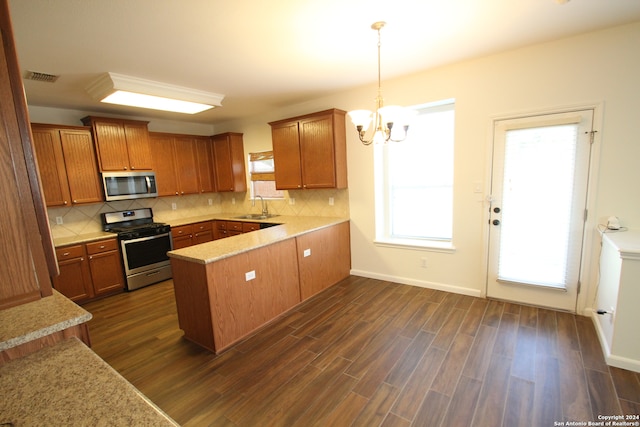 kitchen with a healthy amount of sunlight, stainless steel appliances, dark hardwood / wood-style flooring, and sink