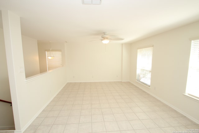 spare room with ceiling fan and light tile patterned floors