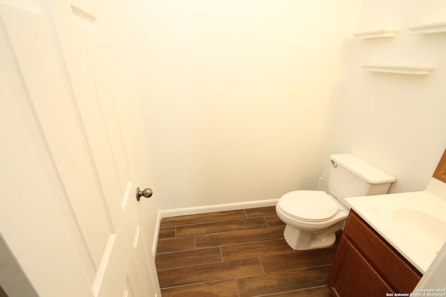 bathroom featuring vanity, wood-type flooring, and toilet