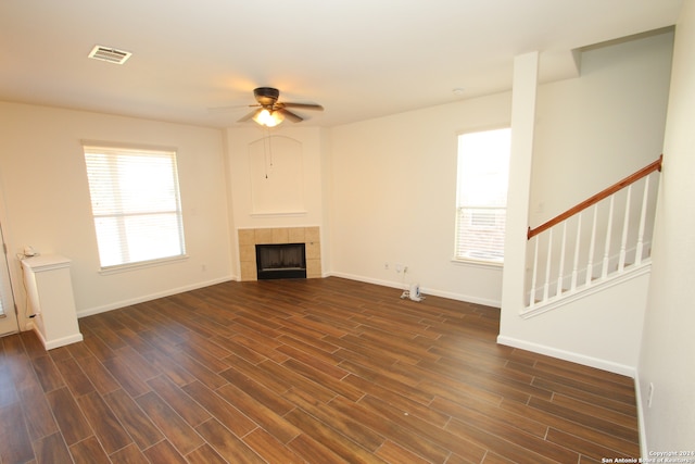 unfurnished living room featuring dark hardwood / wood-style floors, a fireplace, and ceiling fan