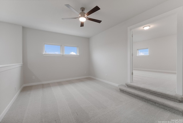 empty room featuring light colored carpet and ceiling fan