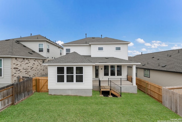 rear view of property featuring a lawn